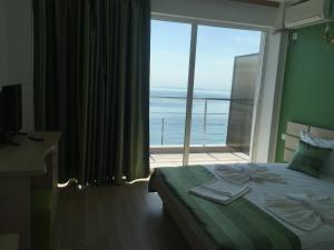 a bedroom with a bed with a view of the ocean at Pensiunea Andra in Costinesti