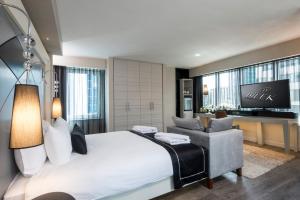 a bedroom with a king sized bed and a chair at Bilek Hotel Kavacık in Istanbul