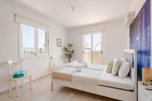 TersephanouにあるMajestic Sea View Apartmentのベッドと窓のある白い寝室 +31枚の写真