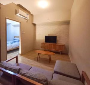 a living room with a couch and a tv at Newton Residence Apartment bm in Bandung