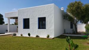 uma casa branca com um jardim verde em Barlovento Tres, Los Caños em Los Caños de Meca