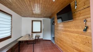 a room with a wooden wall with a table and a tv at Chata Brodský E1064 in Červený Kostelec
