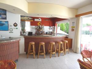 bar w restauracji z czterema stołkami w obiekcie Michalis Studios & Apartments w mieście Kos