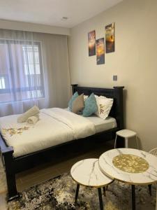 a bedroom with a bed with two tables at Sure Stay Homes in Gatunga