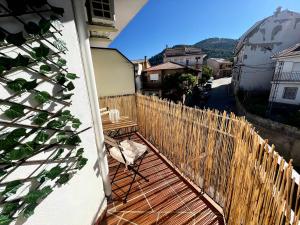 Un balcón con una valla de madera y una silla en Olivae apartamento, en La Iruela