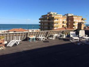 a balcony with chairs and tables and a building at Trilocale sul Mare in Fano