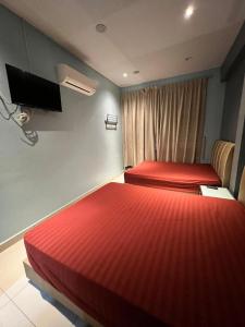 ブキッ・ムルタジャムにあるAlma Sweet Homeのベッド2台 ホテルルーム 赤いシーツ付