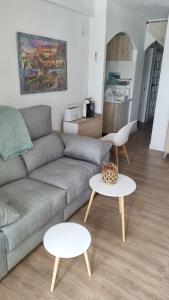 un soggiorno con un divano e due tavoli di Apartamento 309 frente al mar en Alcossebre ad Alcossebre Altre 10 foto