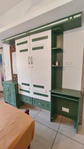 a bedroom with a green and white cabinet and a bed at Ashirvad Homes in Mannārakkāt +65 photos