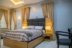 a bedroom with a large bed and a desk at Lakeluxhomes Apartment in Ibadan