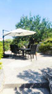 einen Tisch und Stühle unter einem weißen Schirm in der Unterkunft Holiday house Solis in Rab