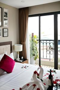um quarto de hotel com uma cama e vista para uma varanda em Golden Moon Suite Hotel em Hanói