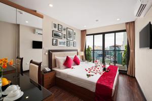 Un dormitorio con una cama con almohadas rojas. en Golden Moon Suite Hotel, en Hanói