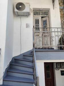eine Treppe in einem Gebäude mit einem Balkon und einer Tür in der Unterkunft flora's memories appartment in Kavala