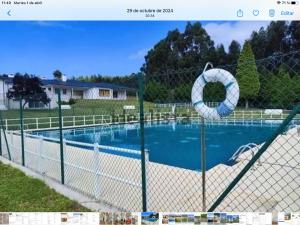 a fence with a swimming pool in a yard at Loft A Mariña Lucense in San Ciprián