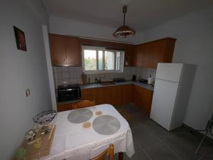 a kitchen with a table and a white refrigerator at Chrisa's Apartments 1 in Missolonghi