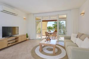 a living room with a couch and a tv and a table at Ilot Bleu, beachfront flat, centre of Grand Baie in Grand Baie