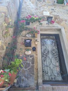 a stone building with a door and some flowers at Casina del castello in Castelnuovo della Misericordia