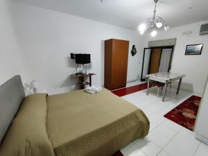 a bedroom with a bed and a table and a television at Casa Campus in Messina