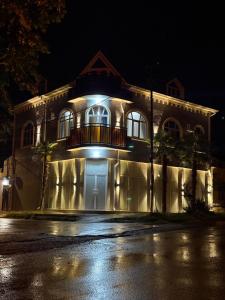 a building with a balcony on the side of it at night at Sheki GuestHouse in Sheki