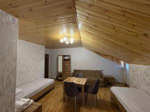 a room with a bed and a table with chairs at Sheki GuestHouse in Sheki