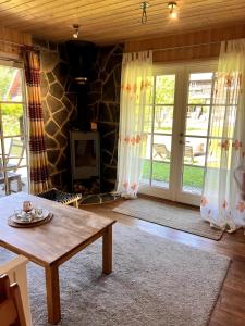 a living room with a table and sliding glass doors at Norwegian saunahouse in Haapse
