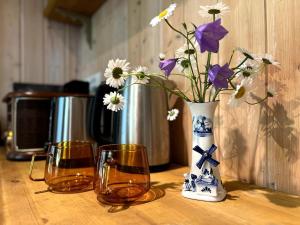 a table with two glasses and a vase with flowers at Norwegian saunahouse in Haapse