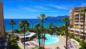 Una vista de un resort con piscina y el océano. en Azuréa, vue mer avec ses 2 piscines, en Cannes