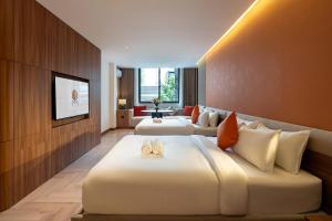a hotel room with two beds and a television at Metrolux City Contemporary Hotel in Ho Chi Minh City