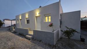 a white house with some plants in front of it at PAME apartments in Kámpos