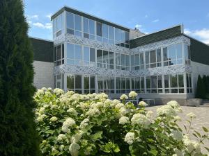a building with white roses in front of it at Гостевой дом SUN TAG in Chornomors'ke