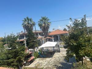 a house with palm trees in front of it at Erifyli in Nea Kallikrateia
