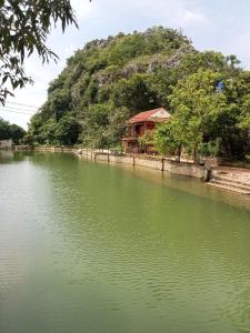 a house on a hill next to a river at Hoa lu Eco Homestay in Ninh Binh