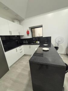 una cucina con bancone nero e armadietti bianchi di Vila Ramos II-Funchal a Funchal Altre 4 foto