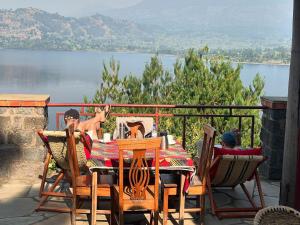 a table and chairs with a view of a lake at cyuza paradise island in Nyarugina +38 photos