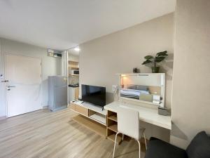 a white room with a desk with a television and a refrigerator at Studio16 at Changwattana in Ban Bang Phang