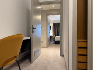 un corridoio con una camera con un letto e una sedia di Suites Marilia Apartments Pool Side - Suite Livorno Holiday Home Group a Livorno Altre 227 foto