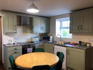 a kitchen with a wooden table and a small kitchen with a table and chairs at Hillcrest Cottage in Carrickfergus