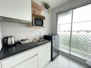 a kitchen with a sink and a refrigerator at Studio123 at changwattana in Ban Bang Phang