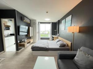a small room with a bed and a couch at Studio123 at changwattana in Ban Bang Phang