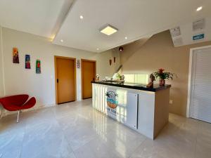 圣路易斯Your Home - Studios Boutique Hotel的客厅配有柜台和红色椅子