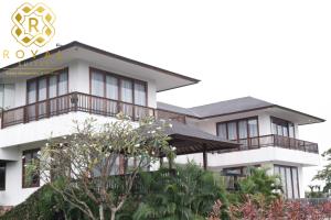 にあるVilla Harimau - Oakwood by Royal Suitesのバルコニー付きの白い大きな建物