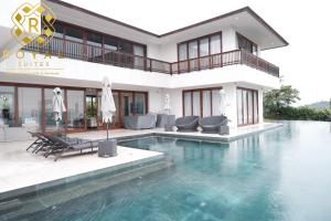 にあるVilla Harimau - Oakwood by Royal Suitesの家の前にプールがある家