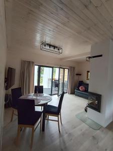 a living room with a dining room table and chairs at Szumiące Drzewa in Debina