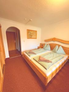 ゲルロスにあるGasthof Oberwirtの部屋の中に大きなベッドがある寝室 +6枚の写真