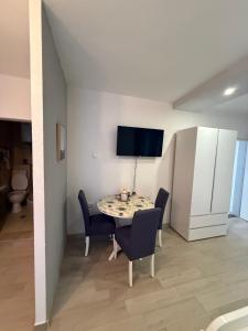 a dining room with a table and chairs and a tv at Apartments Nikola in Gradac