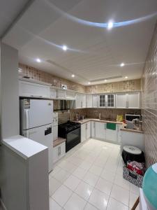 a kitchen with white cabinets and a blue light on the ceiling at شقة مفروشة فاخرة حي الواحة in Jeddah
