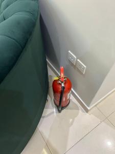 a red object sitting on the floor next to a couch at شقة مفروشة فاخرة حي الواحة in Jeddah +2 photos