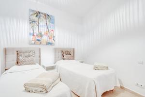 two beds in a room with white walls at Duende Marbella in Marbella +39 photos