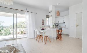 a white kitchen with a table and white chairs at Duende Marbella in Marbella